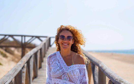 Woman walking on the beach wearing sunglasses